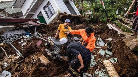 Villagers salvage items from damaged houses following a 5.6-magnitude earthquake in Cianjur on November 22, 2022.
