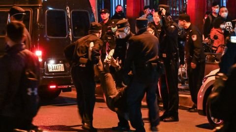 A protester is arrested by police in Shanghai on Sunday night.