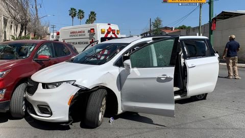 A member of the Mexican security forces stands next to a white minivan with North Carolina plates and several bullet holes.