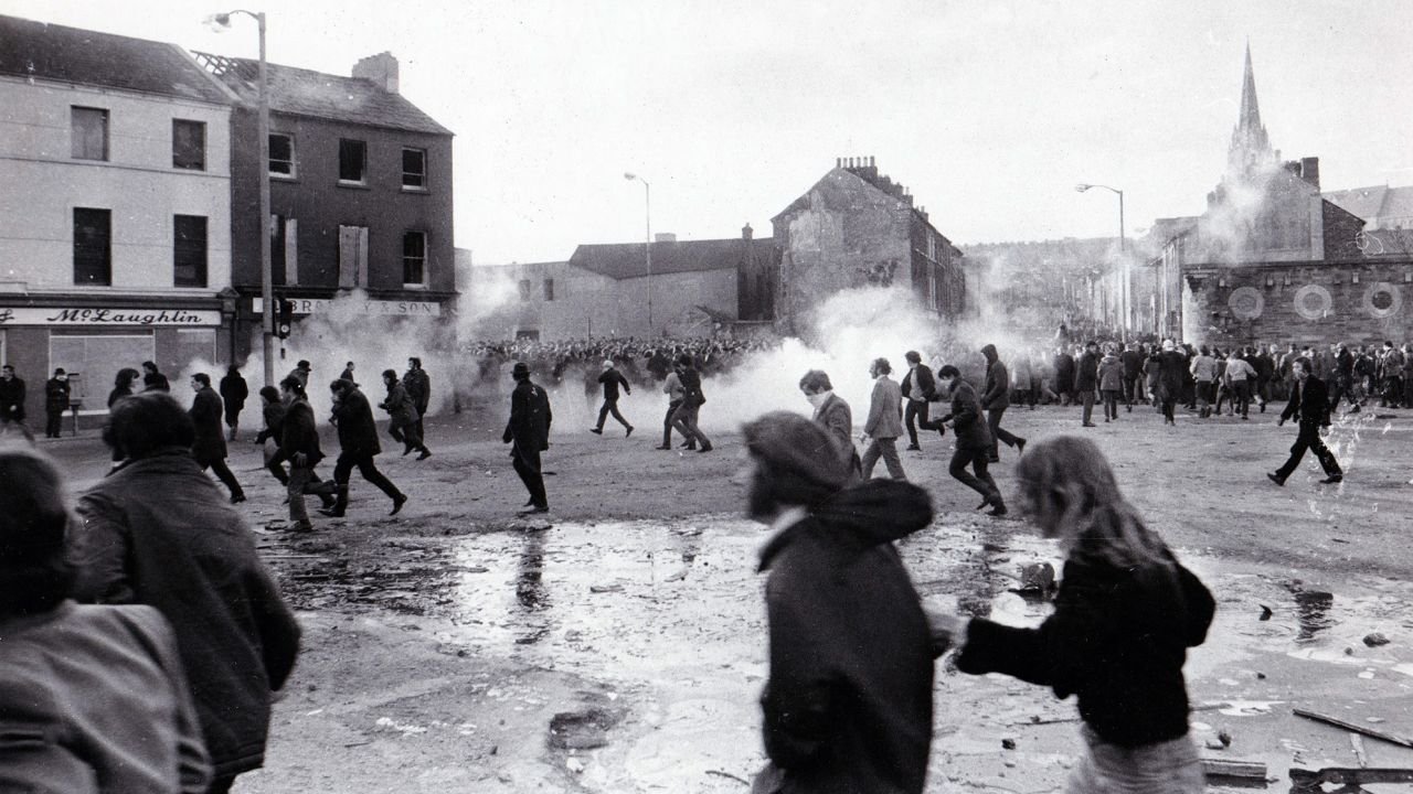 Demonstrators run from tear gas during the 