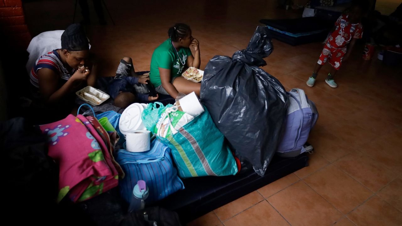 Migrants eat on mats inside a shelter in the San Luis Tlaxialtemalco Forest on May 26, 2023, in Mexico City. 