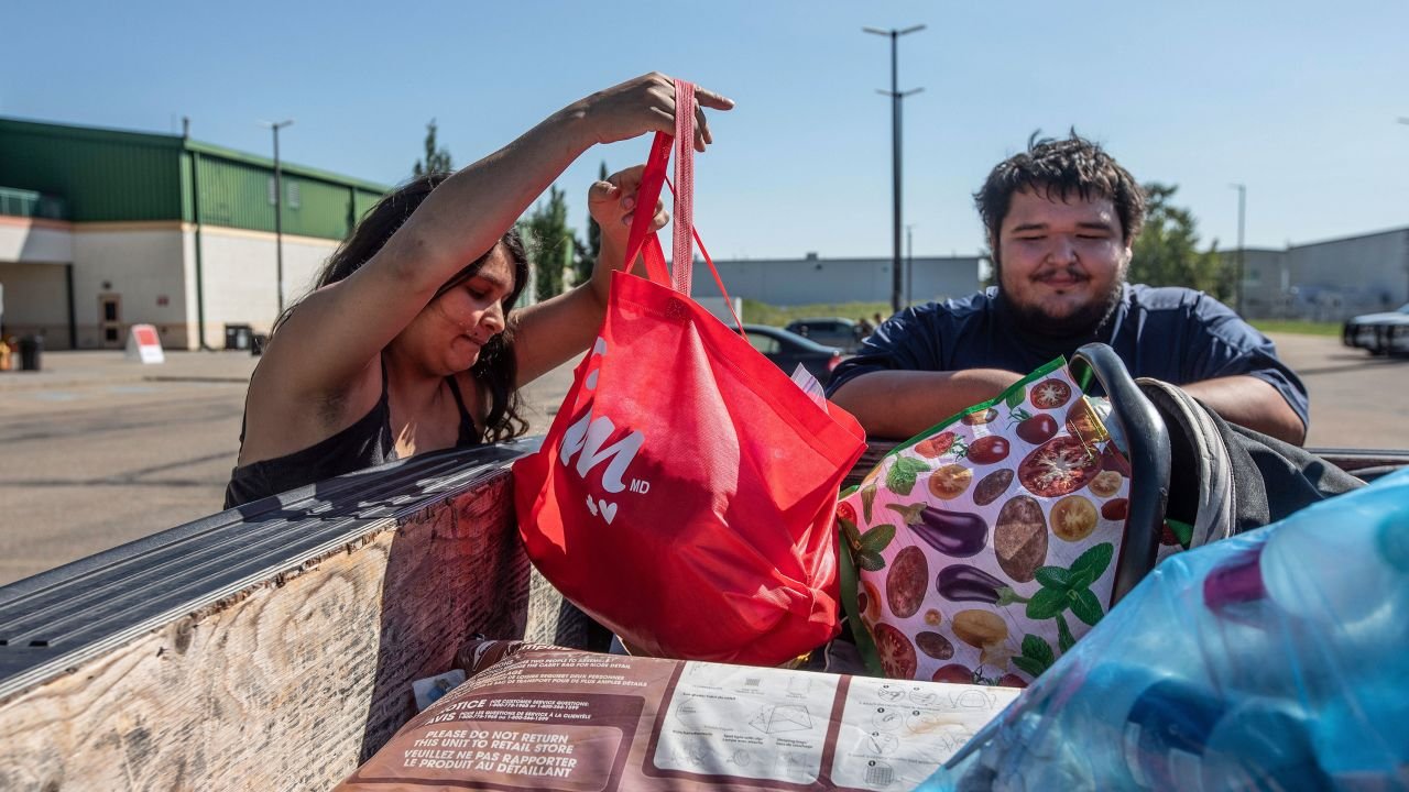 Canadian fire evacuees Tanisha Edison and her boyfriend Mason Bruneau go through their belongings at the evacuee center in St. Albert, Alberta, on August 16.