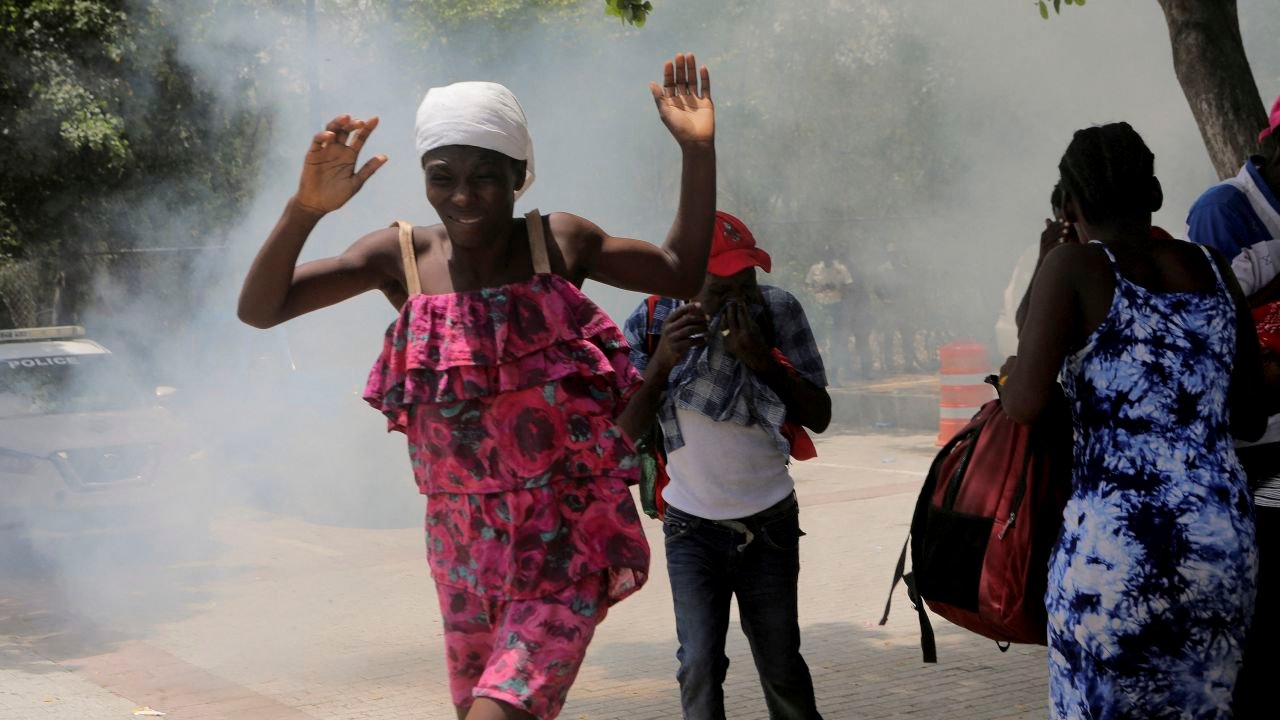 Haitians flee tear gas fired by officers clearing a camp of people at the US embassy seeking to escape the violence of armed gangs on July 25.