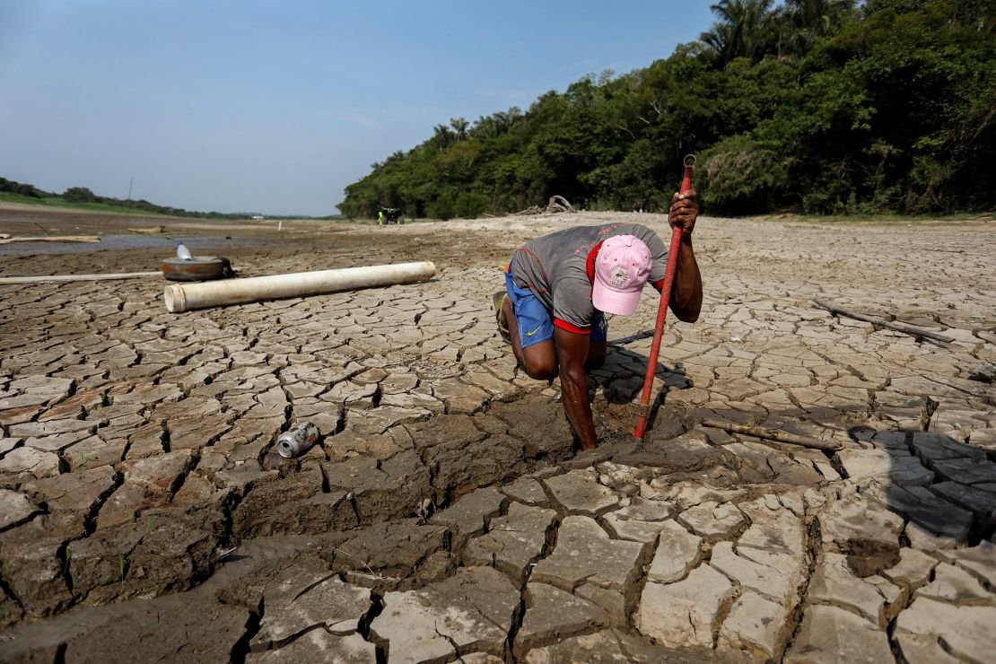 Ivalmir Silva digs a well to obtain water at Lake Puraquequara in Manaus, Amazonas State, Brazil, on October 6, 2023. 