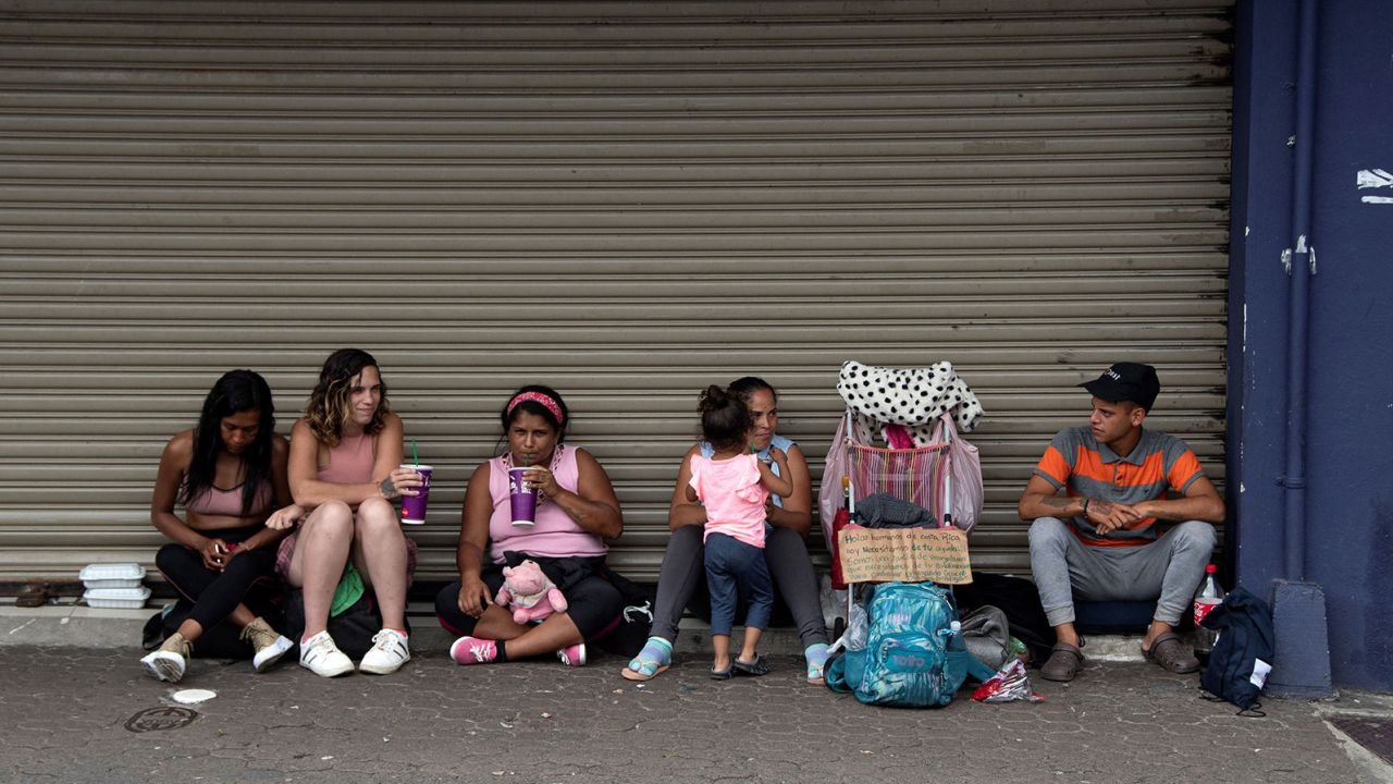 A group of Venezuelan migrants ask for money to continue their journey to the United States in San Jose, Costa Rica, on October 13, 2022.