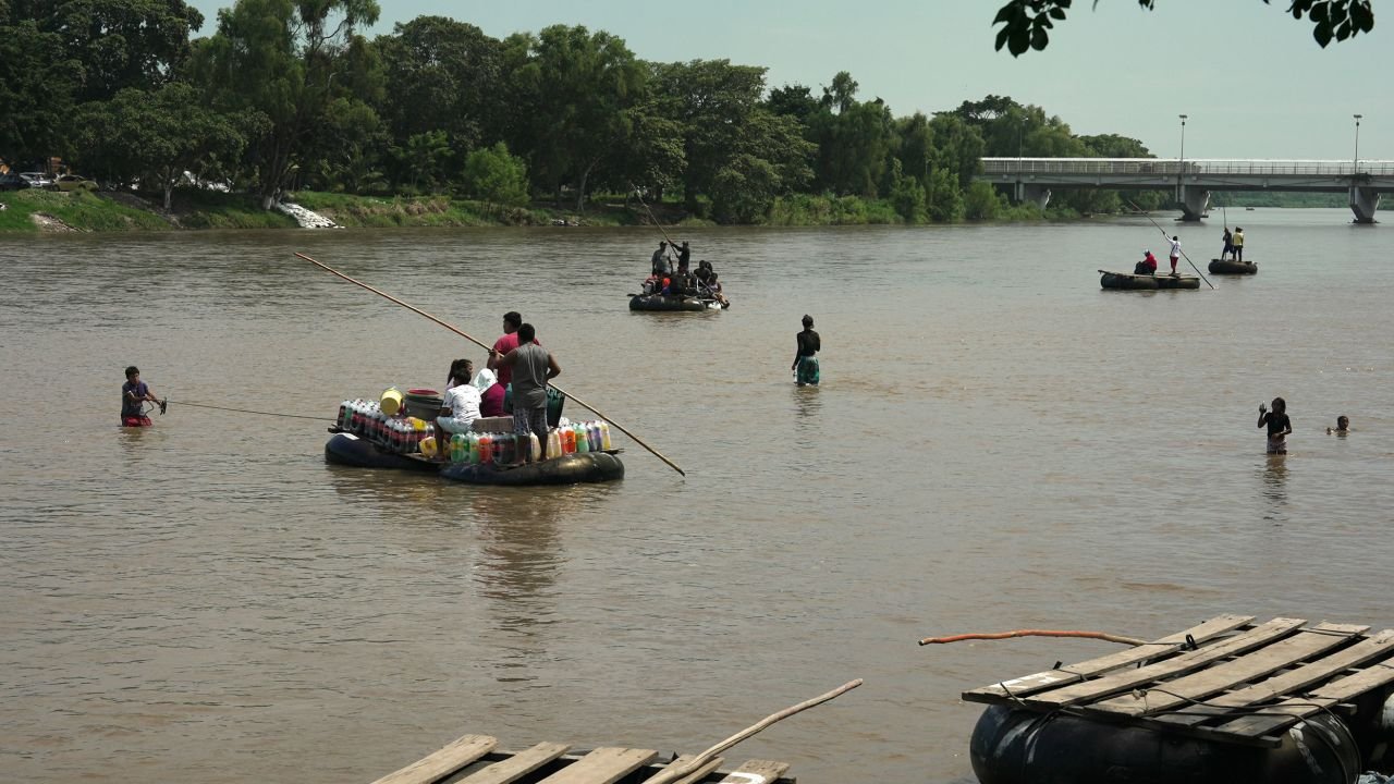 Migrants cross the Suchiate River between Guatemala and Mexico on makeshift rafts.